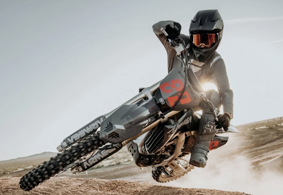 Rider leaning into a turn on motocross bike, wearing tinted goggles with injection-moulded lens for clarity and protection
