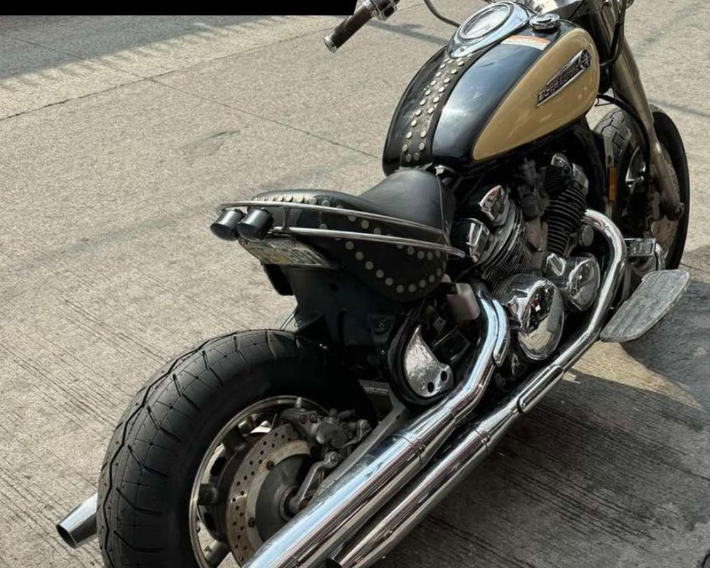 Close-up of a cruiser motorcycle with chrome pipes and a Shinko 230 Tour Master rear tire