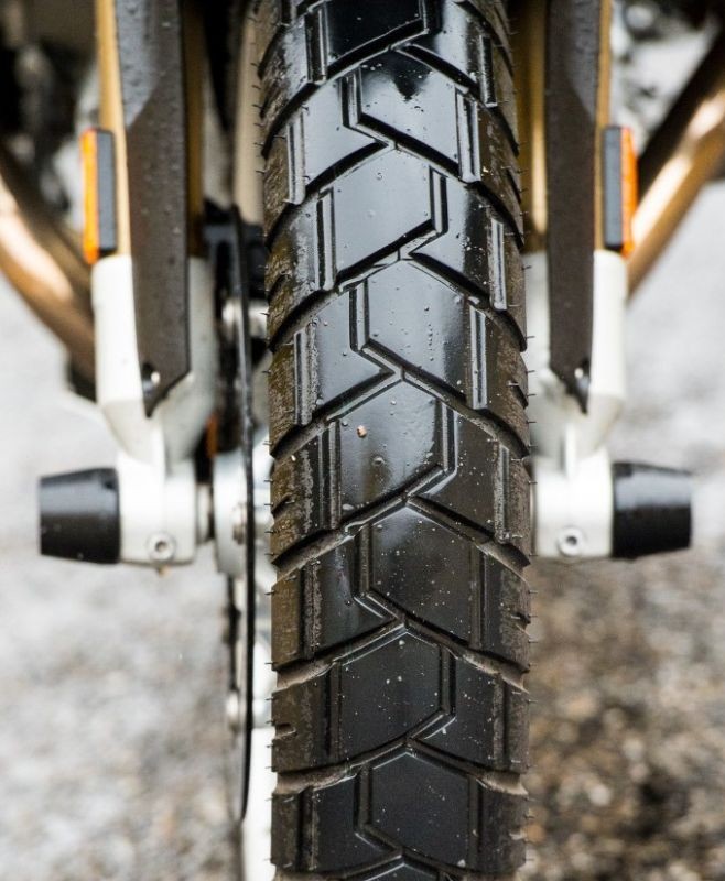 Close-up of Shinko 705 dual sport tire mounted on a motorcycle, showing tread detail