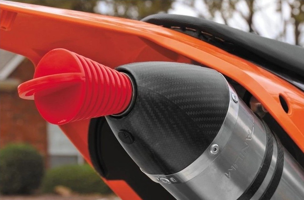 BikeMaster Muffler Rubber Plug inserted in motorcycle exhaust to block moisture and pests during storage.