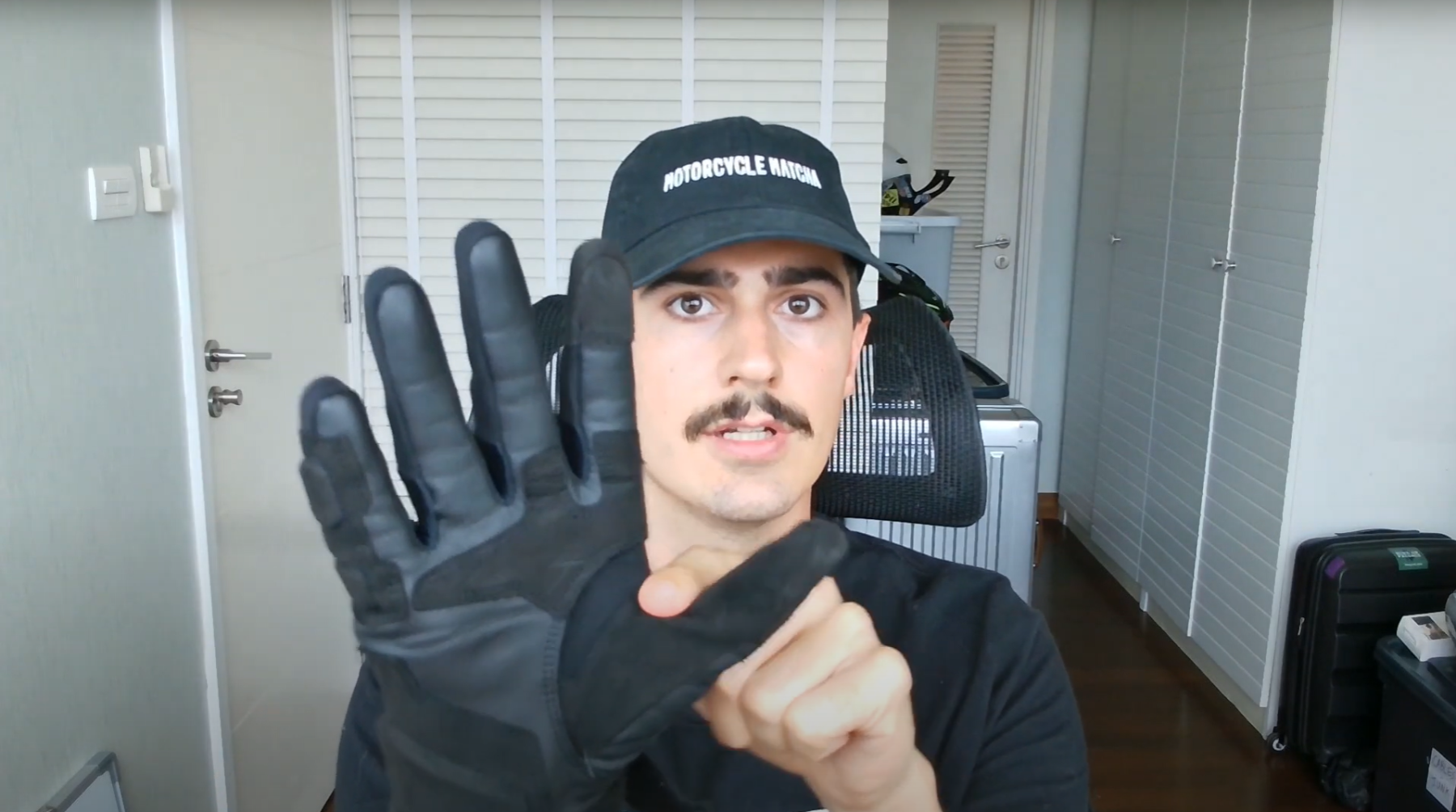 Rider showing Alpinestars Phenom gloves and pointing out fit pressure points