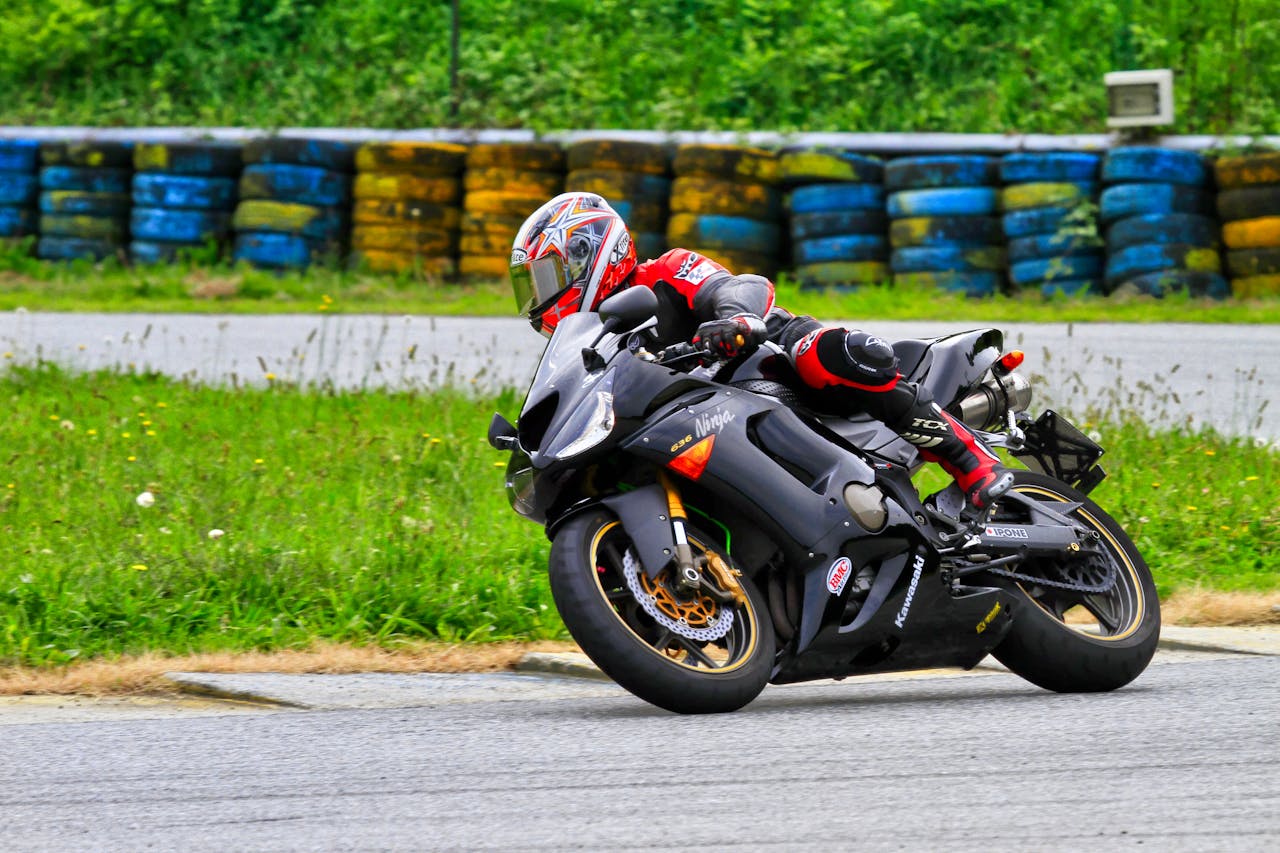 Motorcycle rider leaning into a sharp corner on track, showcasing tire grip and performance at the limit