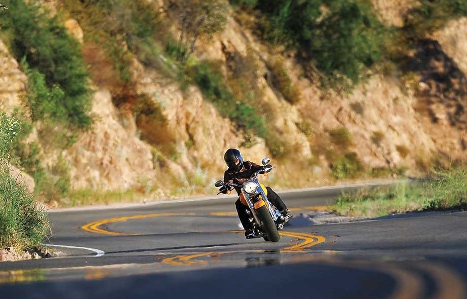 Motorcyclist leaning through a mountain curve showcasing tire stability and smooth handling.