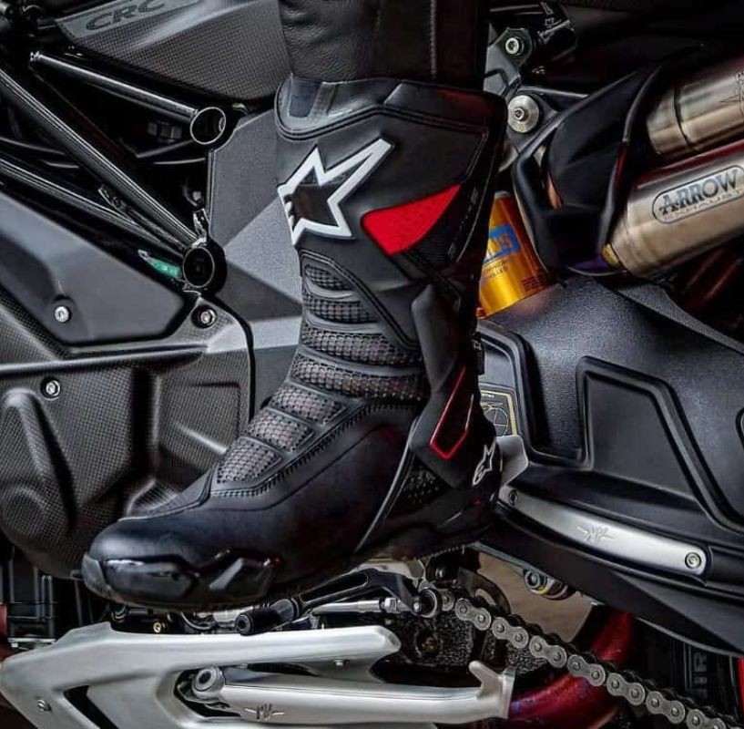 Close-up of a rider wearing Alpinestars SMX-6 V3 boots with a zip-and-Velcro closure, showing secure fit and control on a sportbike.