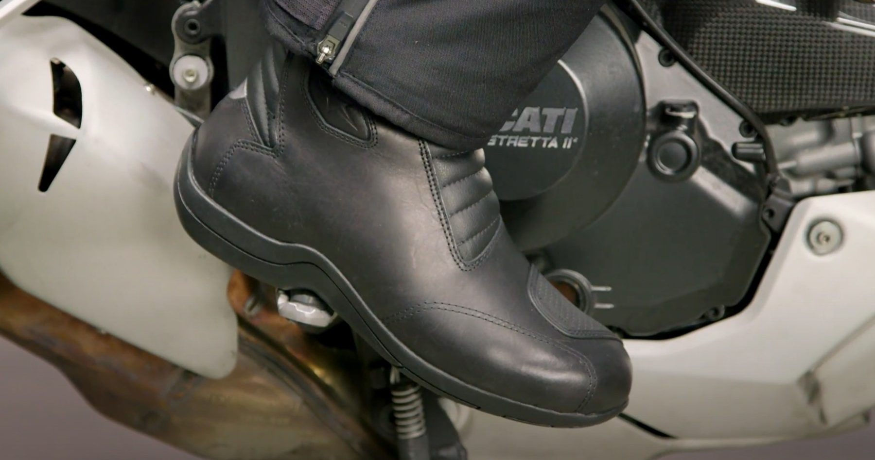 Close-up of a rider’s foot wearing Alpinestars Web Gore-Tex boots on a Ducati motorcycle footpeg.