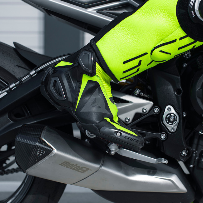 Dainese Axial 2 racing boots on a sportbike — lightweight Kevlar-carbon construction built for MotoGP-level ankle protection.