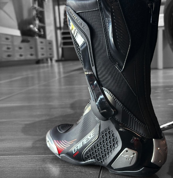 Close-up of Dainese Torque 4 Air motorcycle boot showing D-Axial brace, magnesium sliders, and vented panels for airflow and protection.