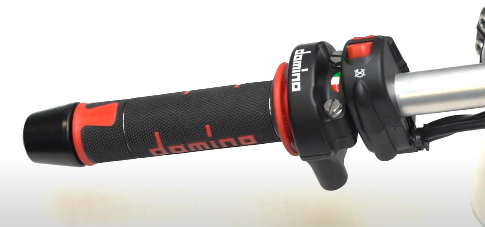 Close-up of Domino A450 Road Racing grips with red accents and textured dual-compound design for sport riders.