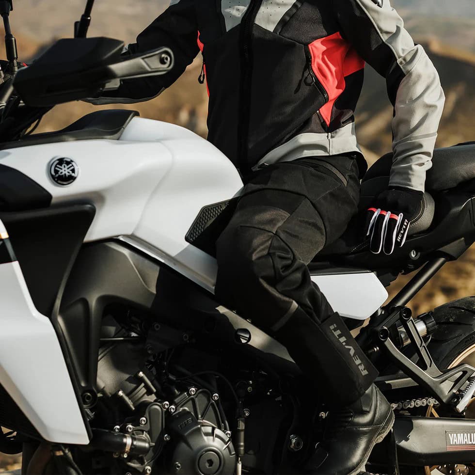 Motorcyclist wearing fitted riding pants and jacket on a Yamaha bike, showcasing streamlined standard-fit motorcycle gear.