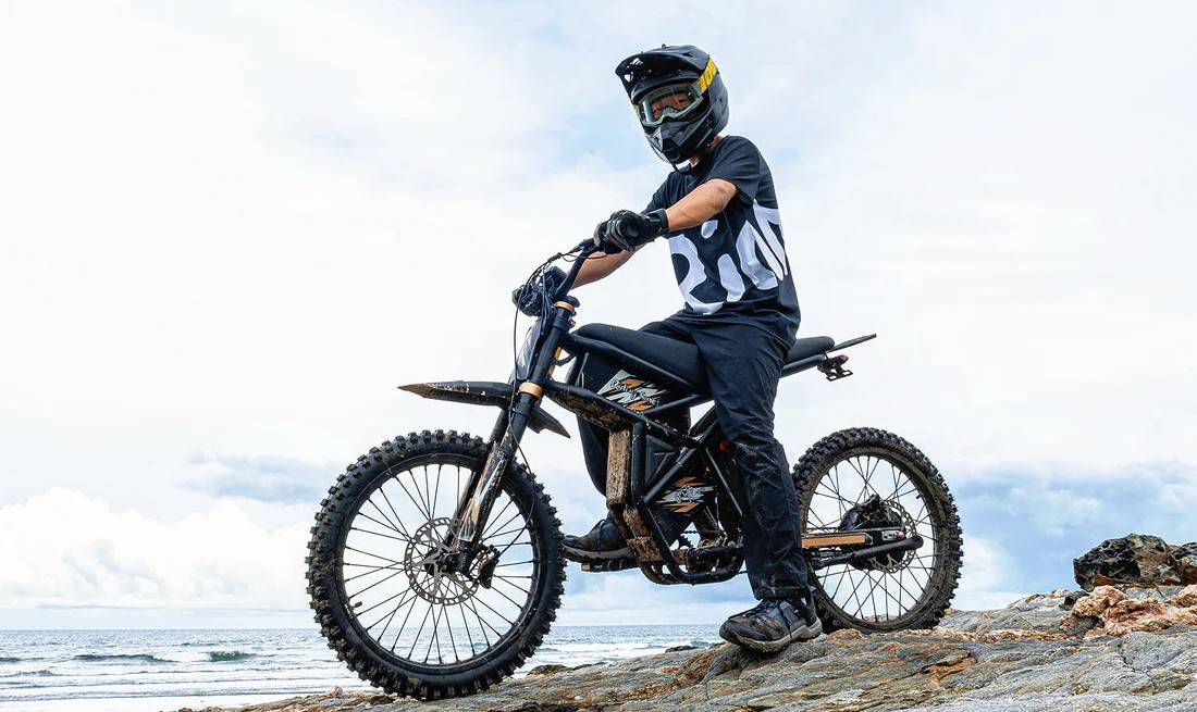 Rider on a RidingTimes GT73 Pro electric dirt bike near the coast