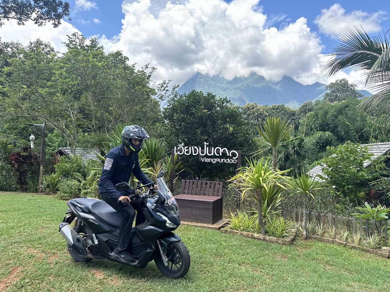 Motorcyclist on a scooter wearing full riding gear in the mountains of northern Thailand, emphasizing safety and proper equipment