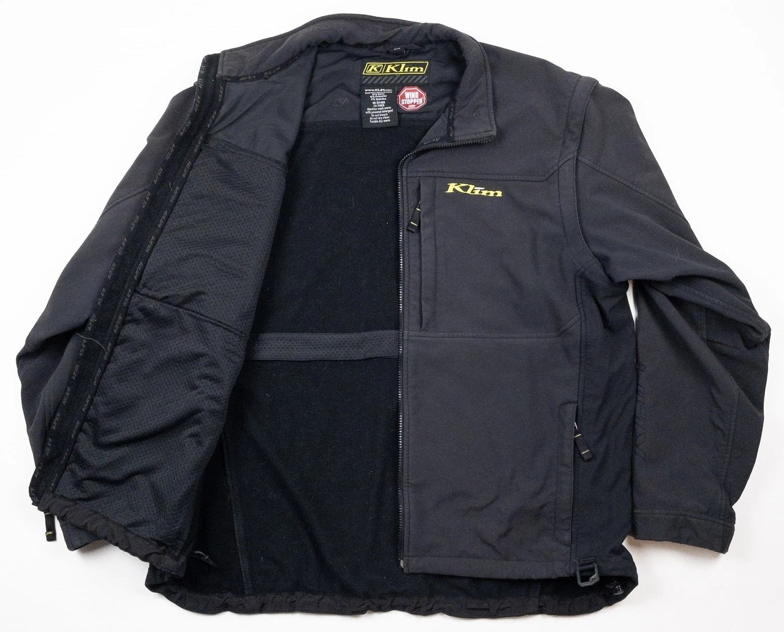 Opened Klim softshell jacket showing interior fleece lining and ventilation panels, highlighting its uninsulated design for layering versatility