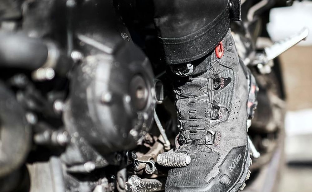 Klim Outlander GTX motorcycle boots on footpeg, featuring Gore-Tex liner, BOA dial, and lugged sole for ADV and street riding.