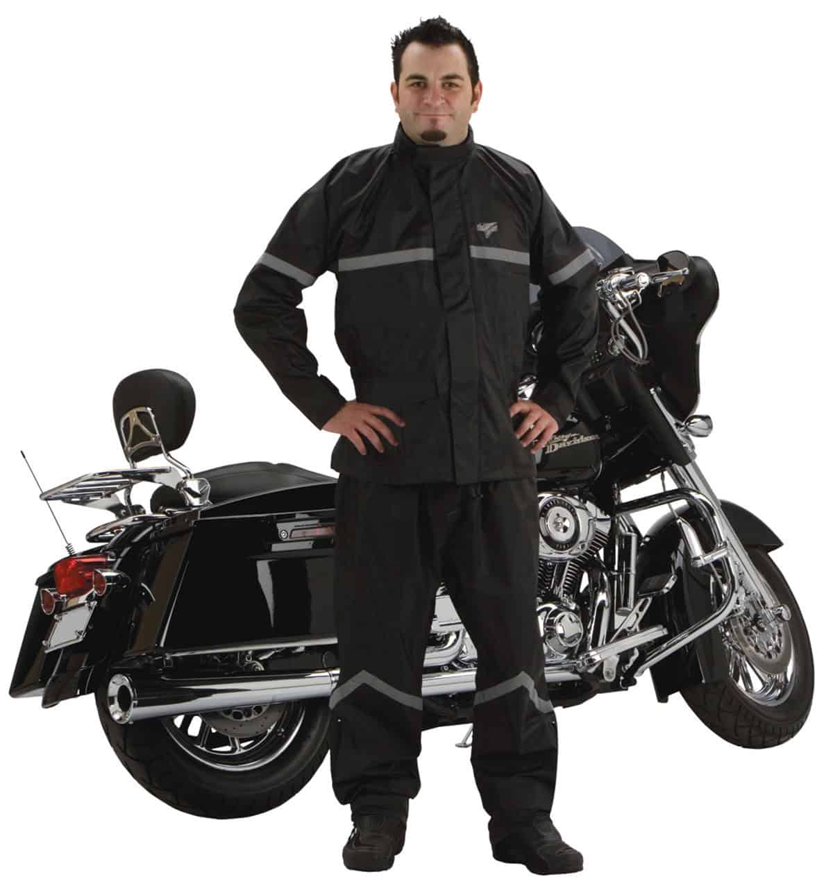 Rider wearing Nelson-Rigg Stormrider two-piece motorcycle rain suit standing beside a touring bike