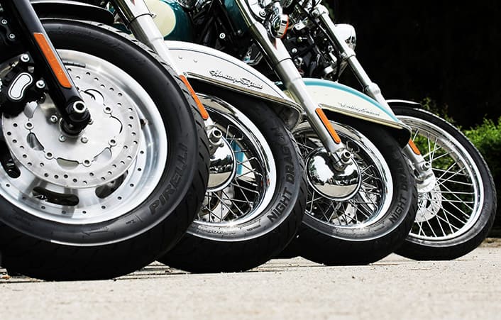 Row of motorcycles fitted with Pirelli Night Dragon tires emphasizing grip and design.