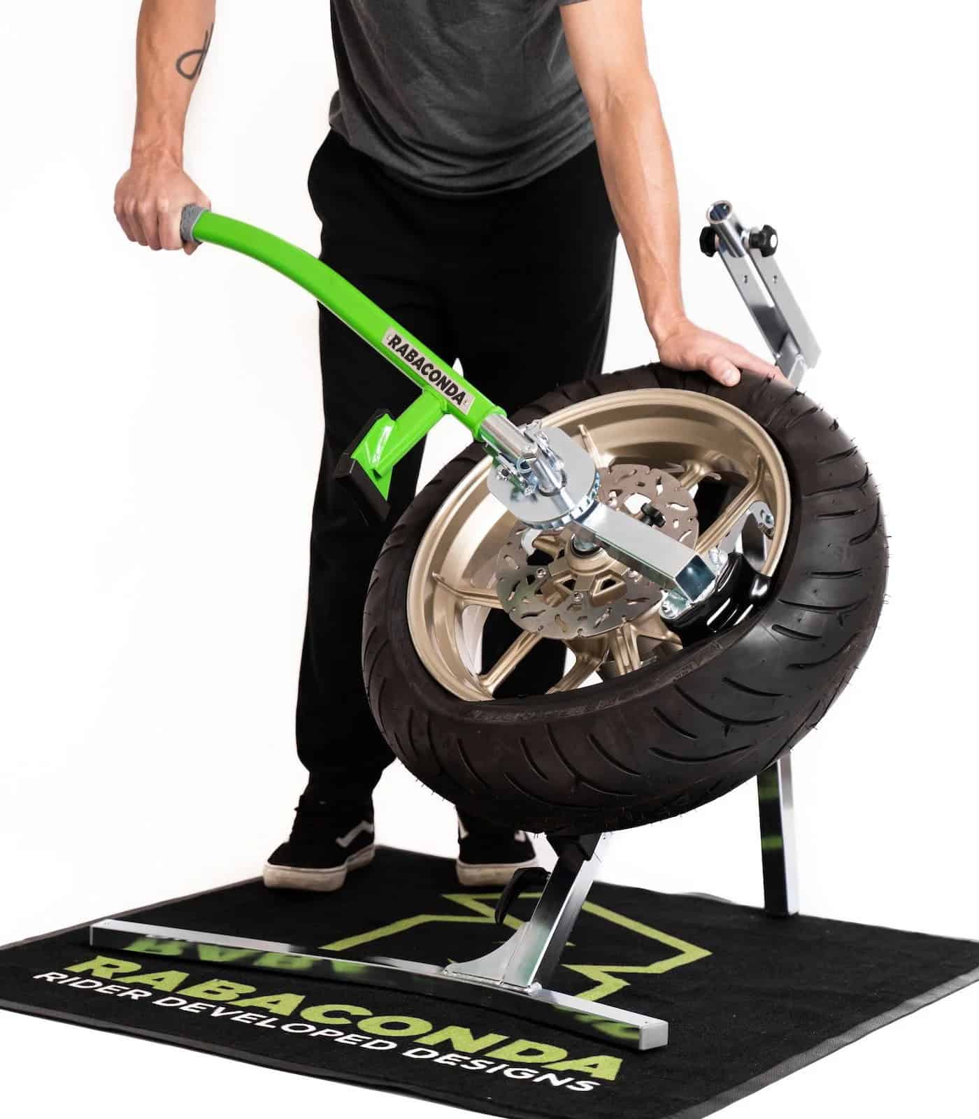 Rabaconda Street Bike Tire Changer in use — a rider swaps a street tire effortlessly using the green lever system.