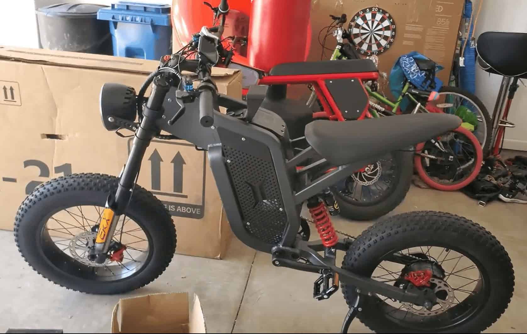 Black Leopard electric fat-tire bike with wide tires and red suspension parked indoors