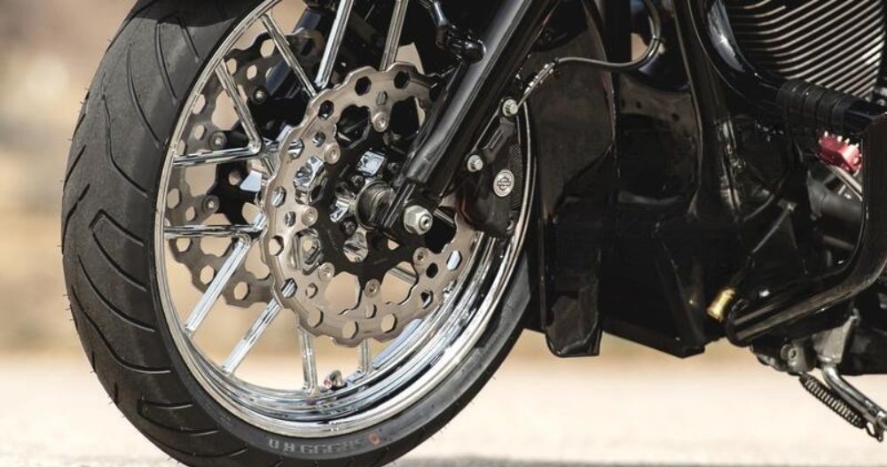 Close-up of a cruiser front wheel fitted with Shinko SR999 Long Haul tire showing tread and chrome detailing.
