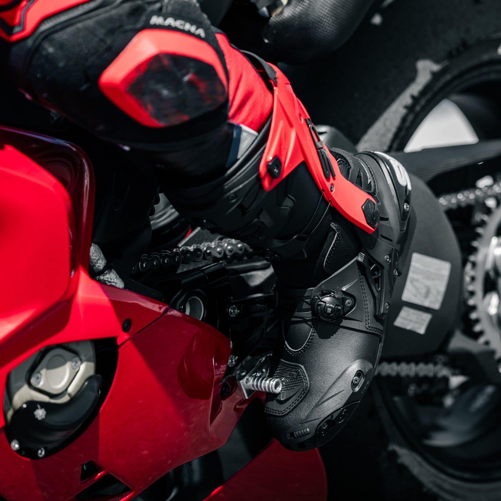 Close-up of Sidi Rex motorcycle boots on a sportbike showing replaceable sliders and external bracing for long-term durability.