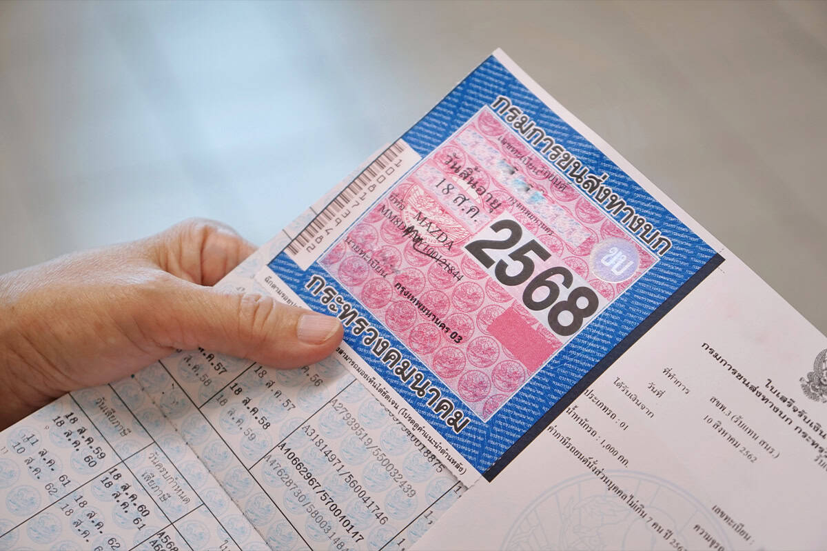 Close-up of a Thai vehicle registration and insurance document showing the Por Ror Bor compulsory motor insurance sticker