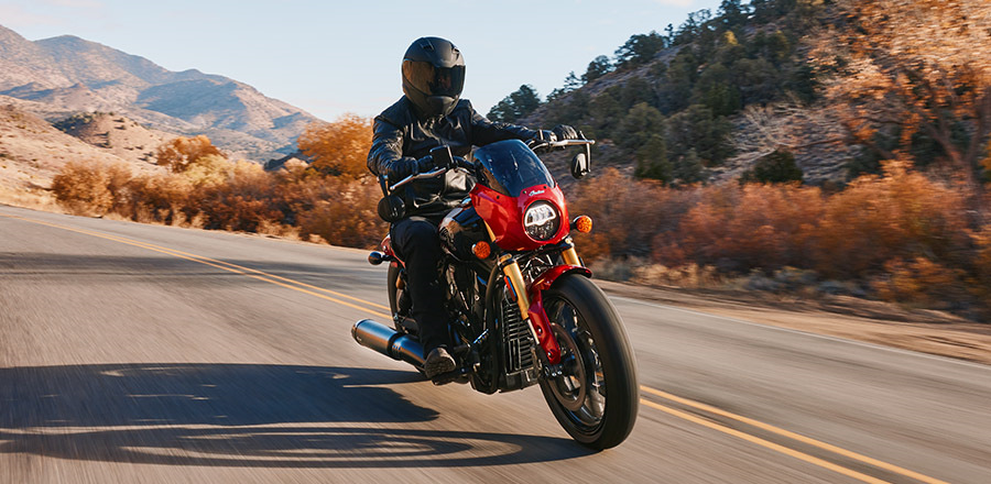 Motorcyclist rides through scenic mountain road at sunset, blending power and control with confidence and ease