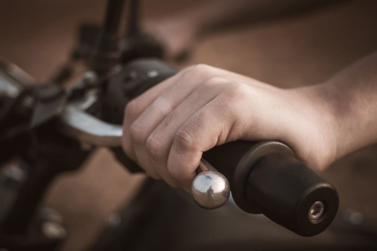 Close-up of a rider’s hand gripping a motorcycle handlebar, showing the connection and control point.