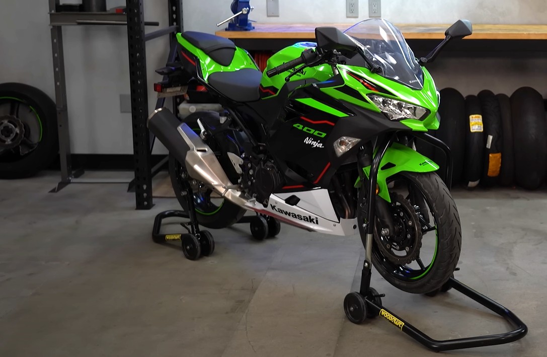 Kawasaki Ninja 400 lifted on front and rear motorcycle stands in a garage