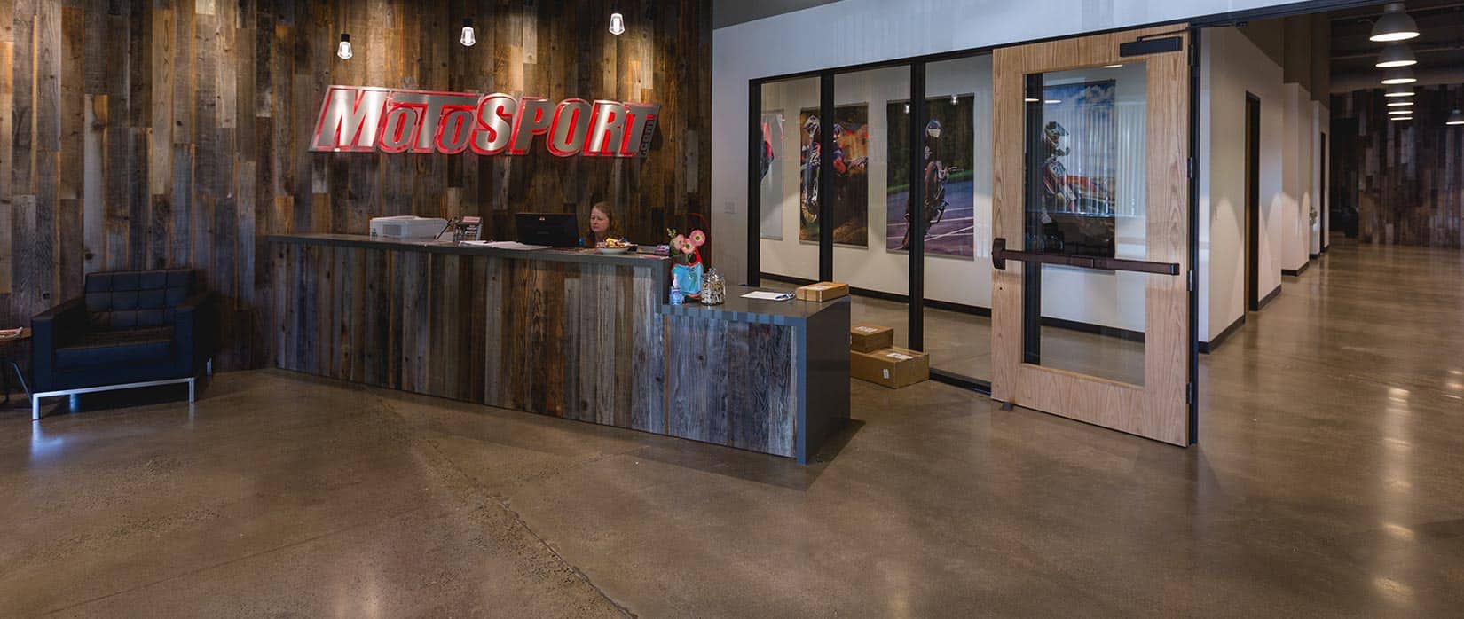 MotoSport office front desk and reception area with logo sign and hallway view inside the company headquarters.