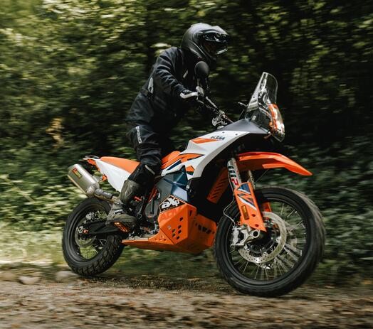 Adventure rider wearing SIDI Adventure 2 Gore-Tex boots while riding an orange KTM dual-sport motorcycle through a forest trail