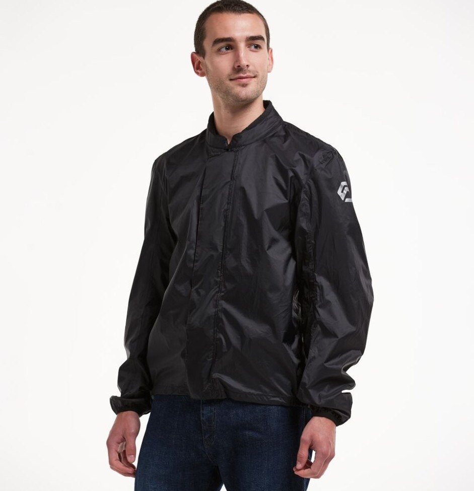 Rider wearing the REAX Traveler waterproof shell jacket designed for compact rain protection