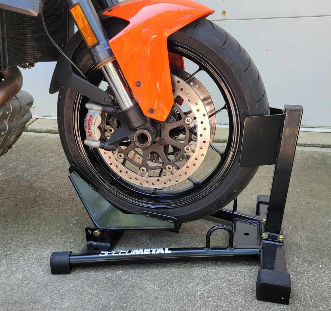Front motorcycle wheel locked in a Speedmetal Roll-In Wheel Chock on a trailer floor.