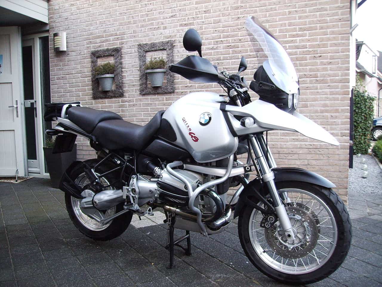 BMW R1150GS adventure motorcycle parked in front of a home, showing its touring-ready design