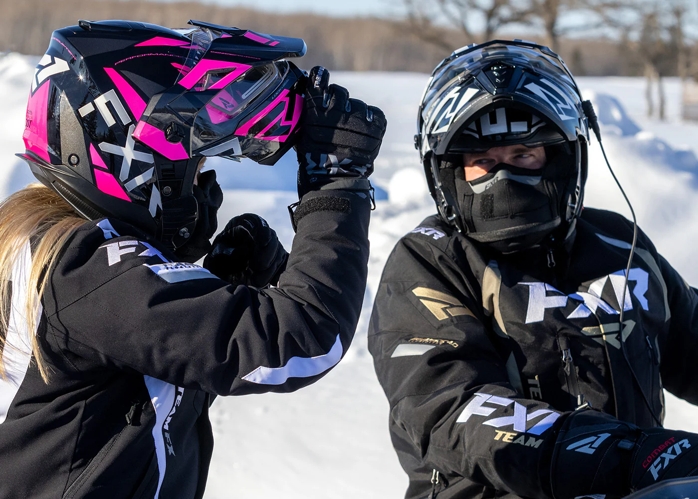 Riders wearing FXR Maverick X Electric modular snowmobile helmets while preparing to ride in snowy terrain
