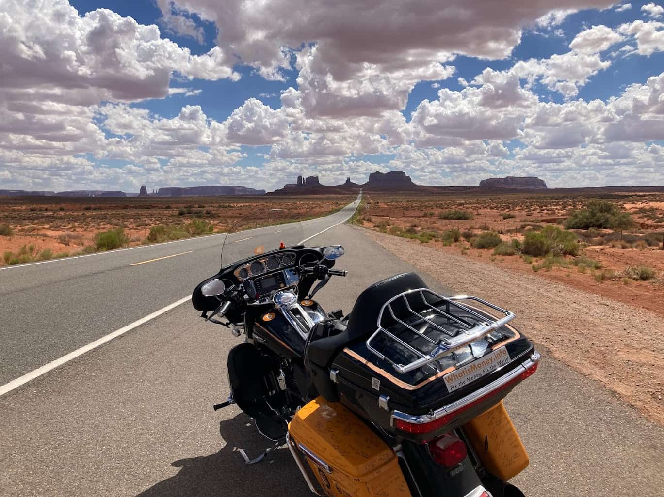 Touring motorcycle parked on a desert highway under bright skies, symbolizing regional differences in insurance costs