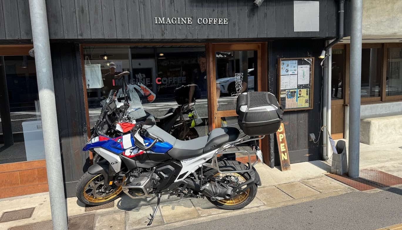 Adventure motorcycle with touring accessories and custom parts parked outside a café