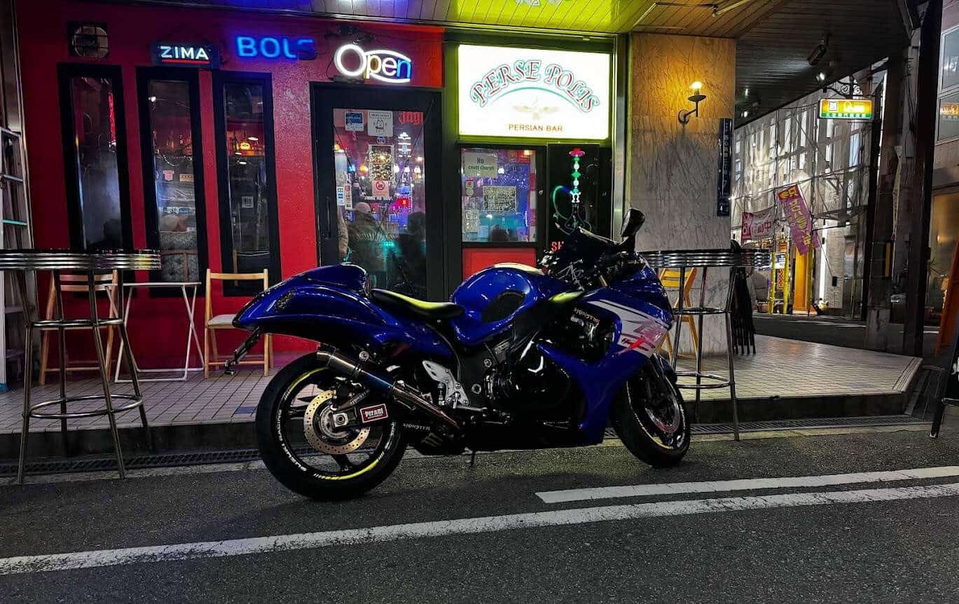 Blue sport motorcycle parked on a city street at night, highlighting the need for comprehensive coverage in urban, theft-prone areas.