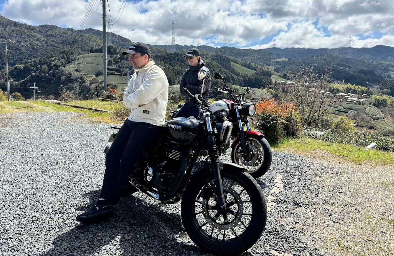 Two motorcyclists taking a break on a scenic mountain road, symbolizing peace of mind and protection with full coverage insurance
