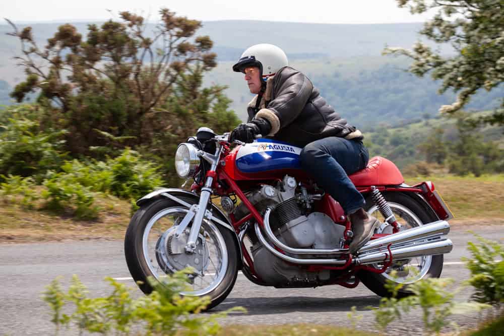Rider on a vintage motorcycle cruising through the countryside on a clear day