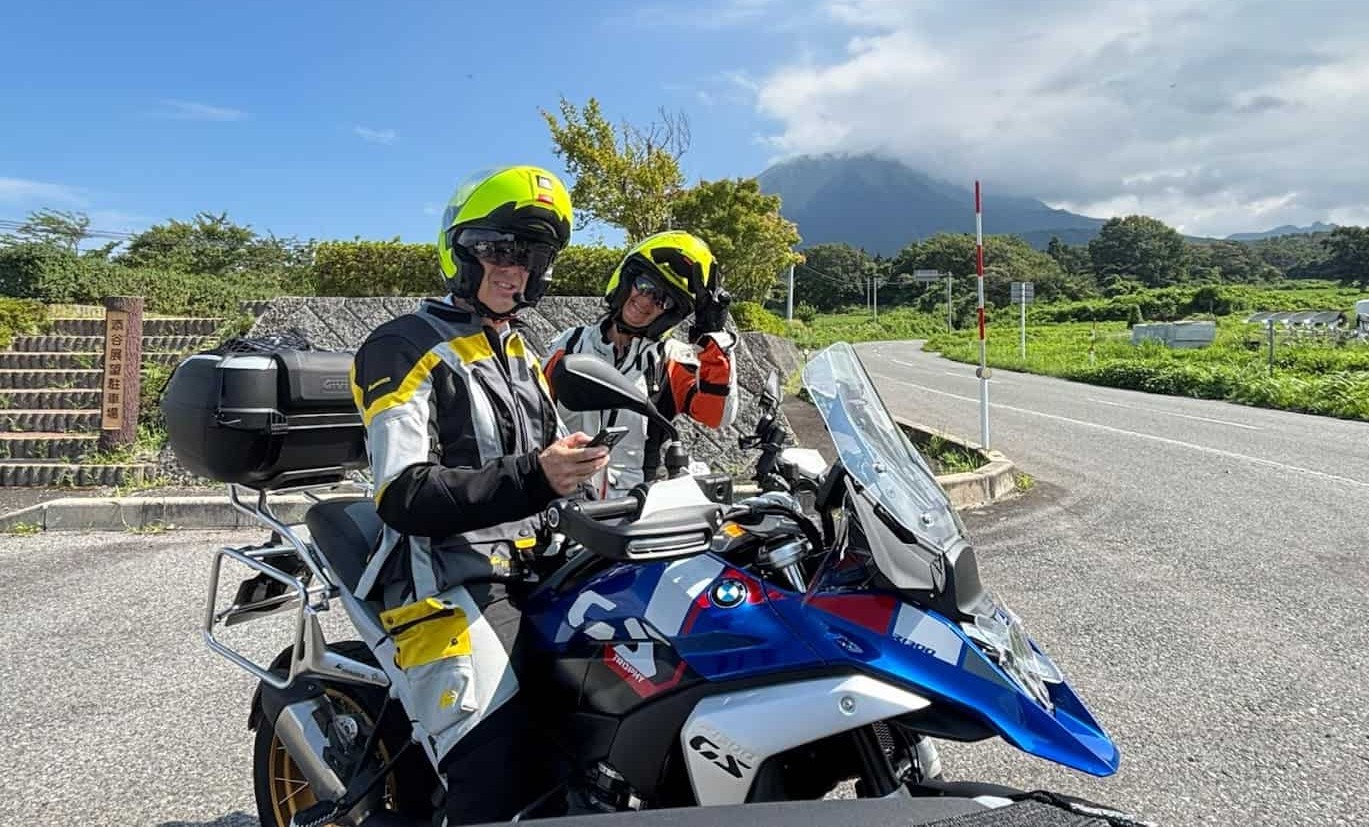 Two riders on a BMW adventure motorcycle smiling during a weekend ride in the countryside