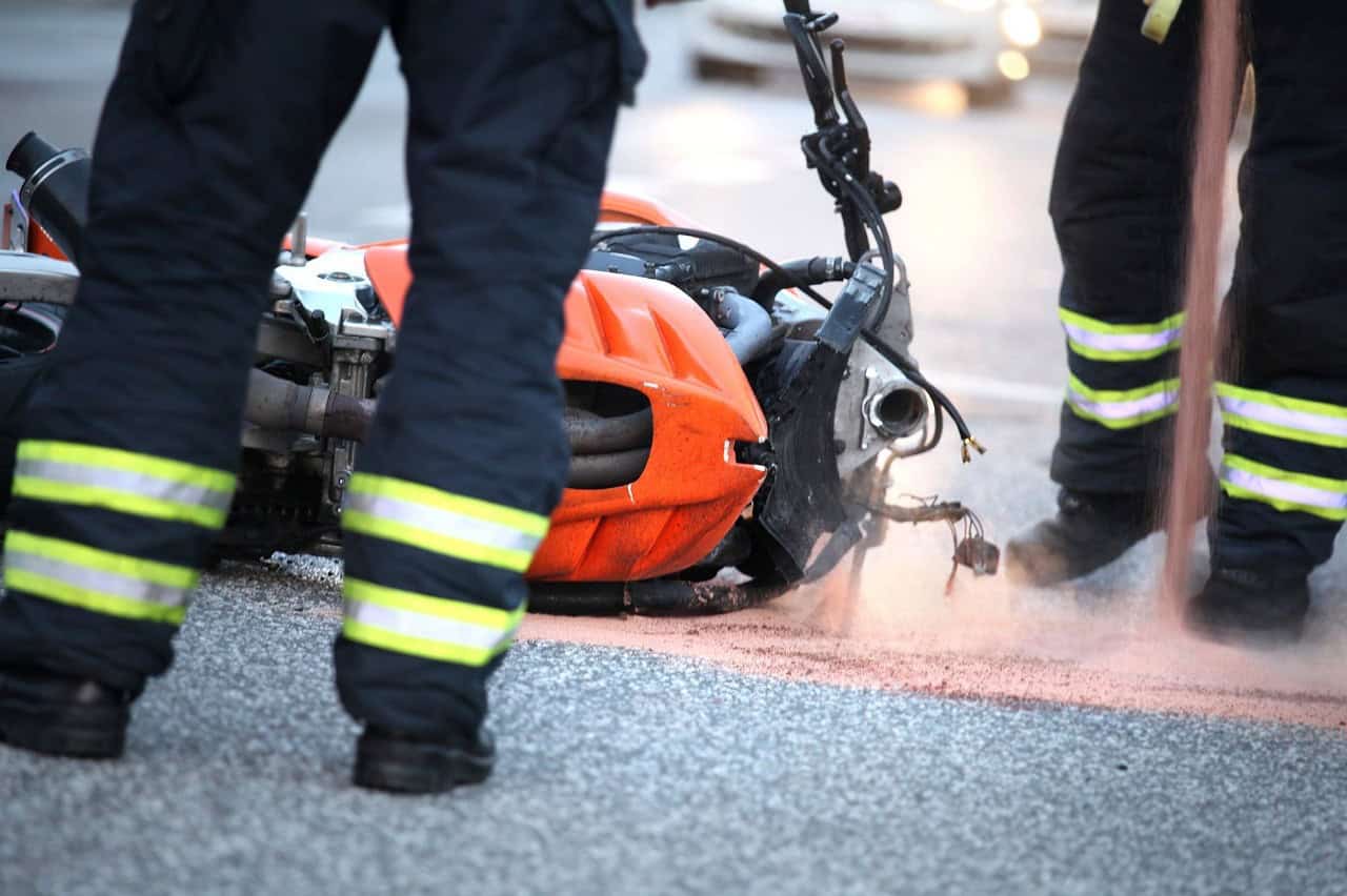 Firefighters assisting at the scene of a motorcycle accident on the road