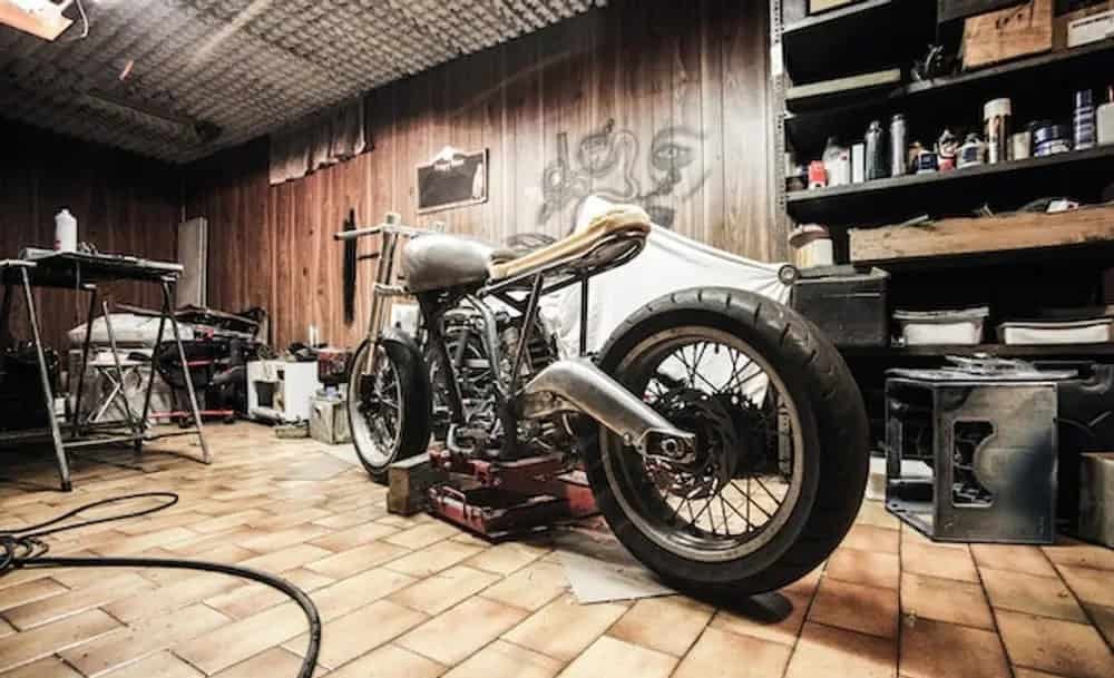 Motorcycle stored in a garage workshop, symbolizing on-base storage for military riders to qualify for insurance discounts.