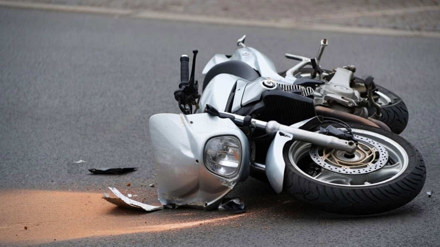 Damaged motorcycle lying on the road after a crash, illustrating the importance of collision and comprehensive insurance coverage