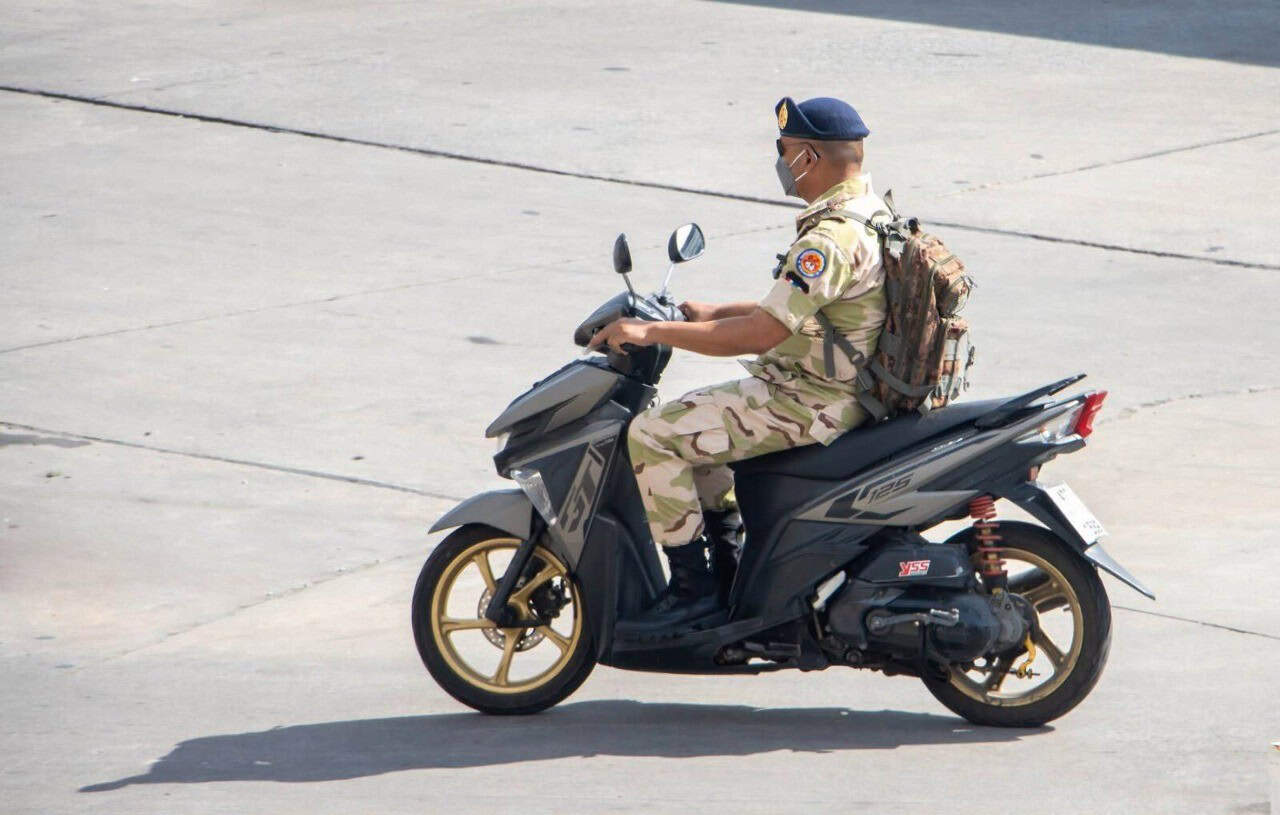 Military rider on a scooter wearing uniform and gear, representing active-duty motorcyclists eligible for USAA insurance discounts.
