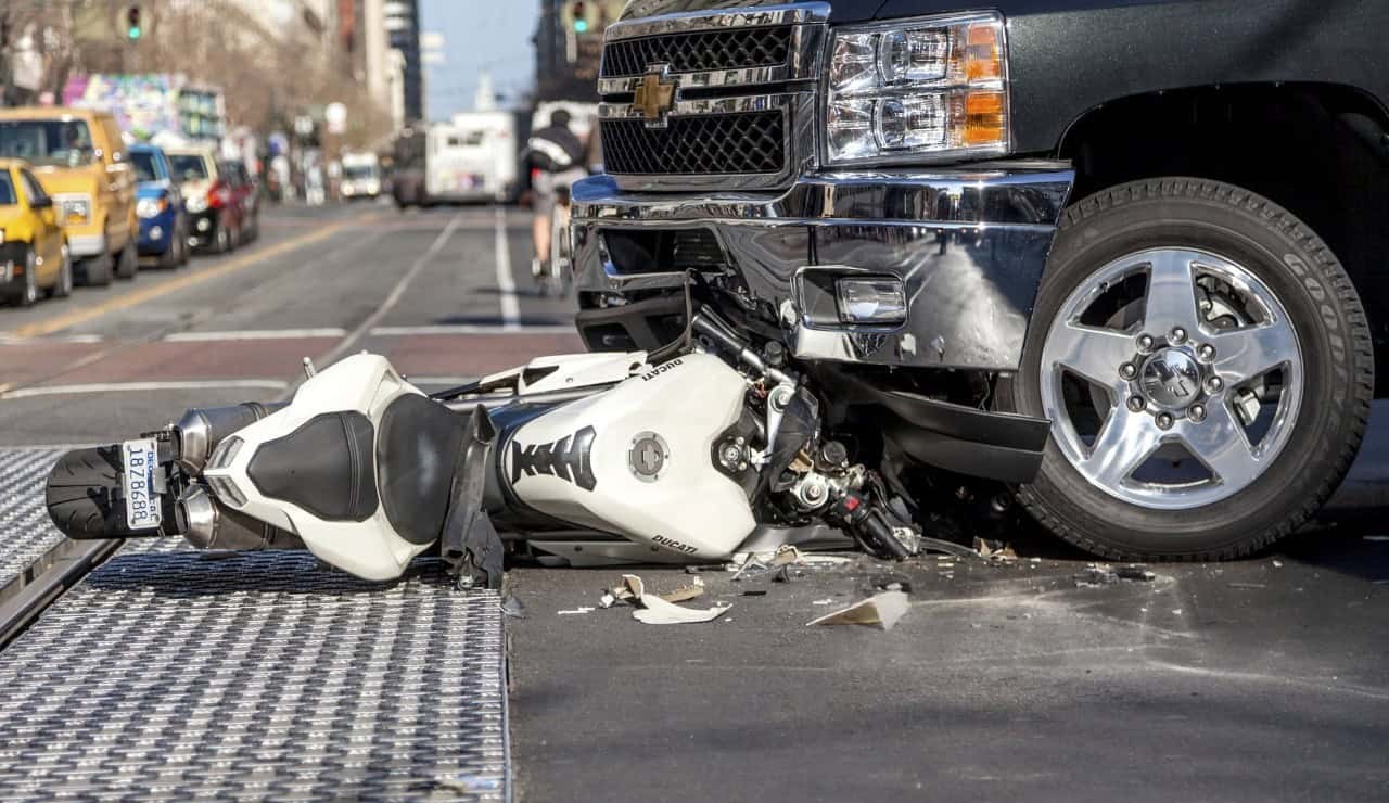 Motorcycle crashed into a truck showing the aftermath of a collision accident on the street