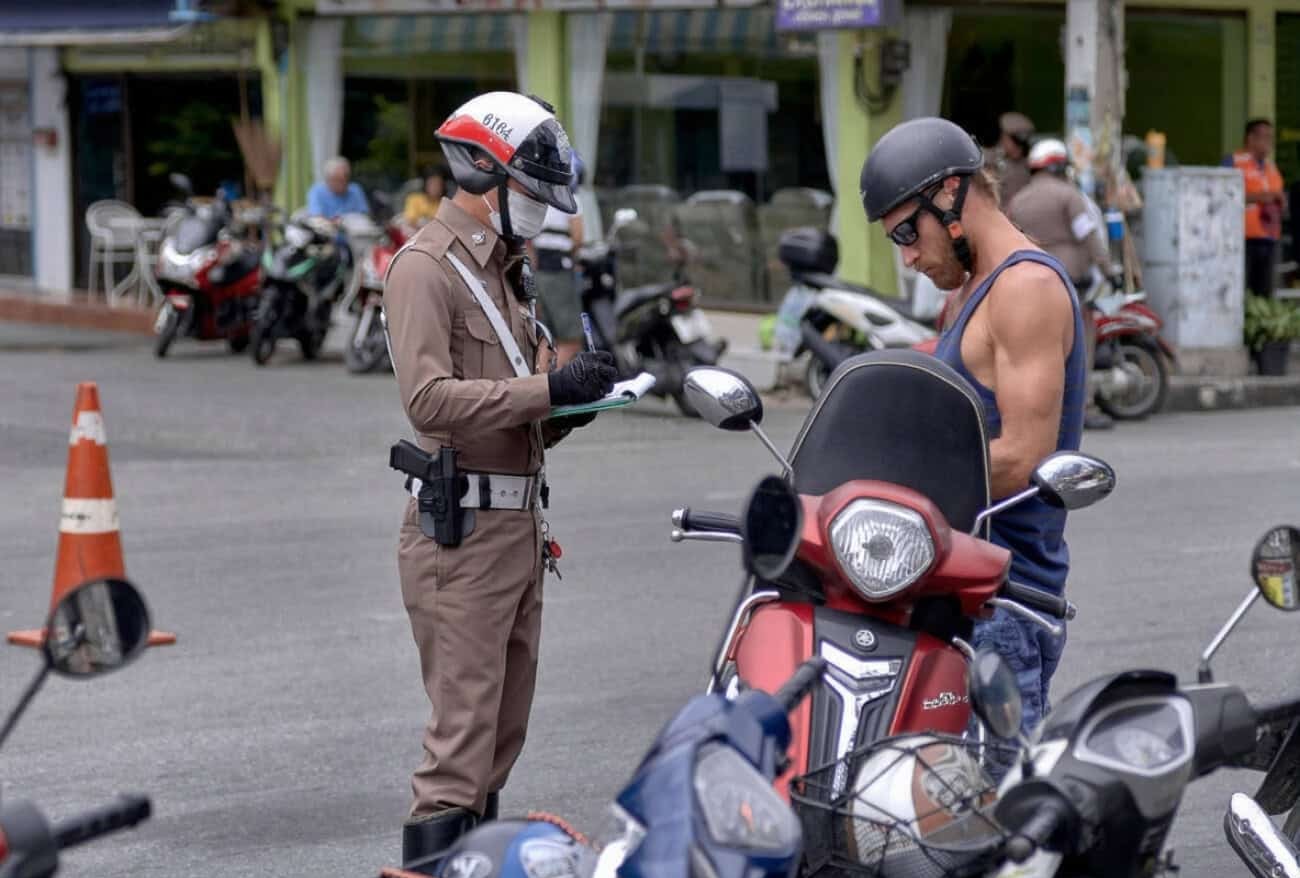 Traffic officer issuing a ticket to a motorcyclist—illustrates how violations can increase motorcycle insurance rates.