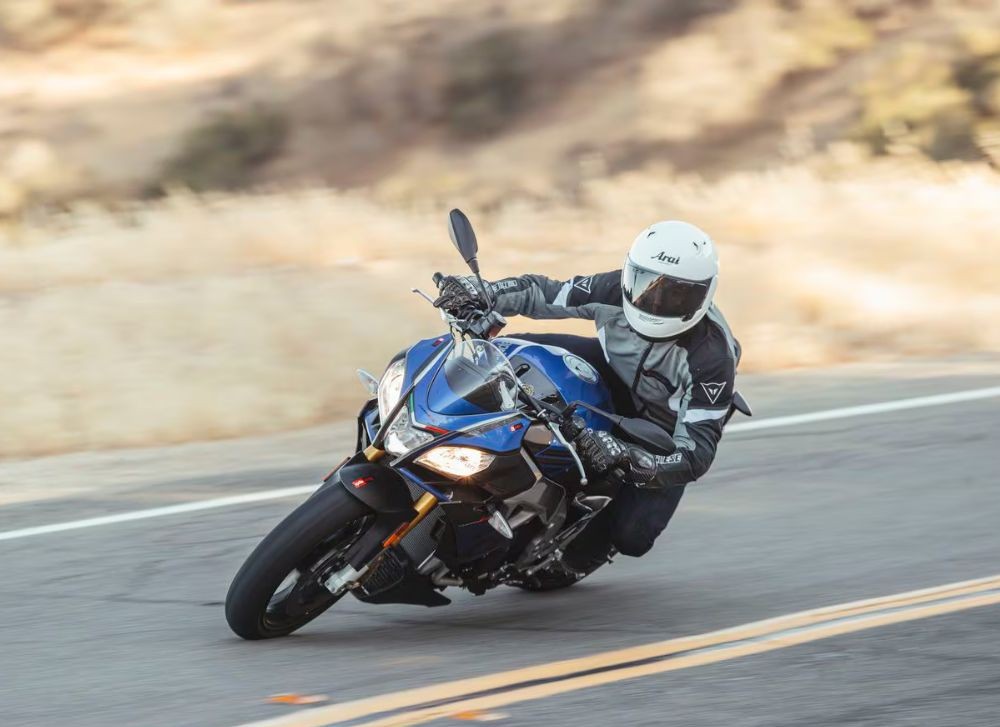 Rider wearing Arai Signet-X helmet leaning into a turn on a sportbike