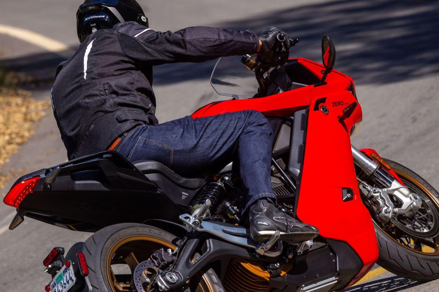 Rider wearing Cortech AA Dyneema riding jeans on a red motorcycle during a turn