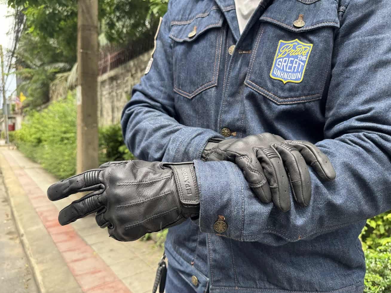 Rider wearing Pando Moto Ivy perforated leather motorcycle gloves with a denim riding jacket