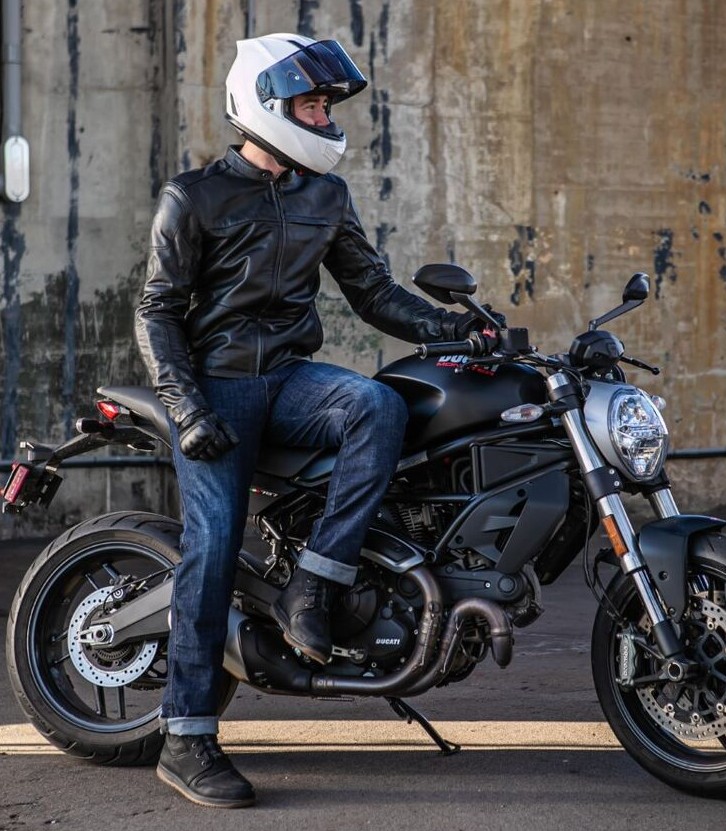 Motorcyclist wearing REAX 610 riding jeans sitting on a naked motorcycle, showing casual style with protective gear