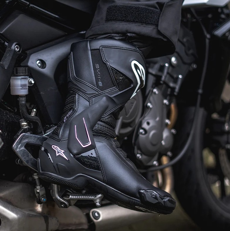 Rider wearing Alpinestars SMX-6 V3 Drystar motorcycle boot on a sport bike footpeg